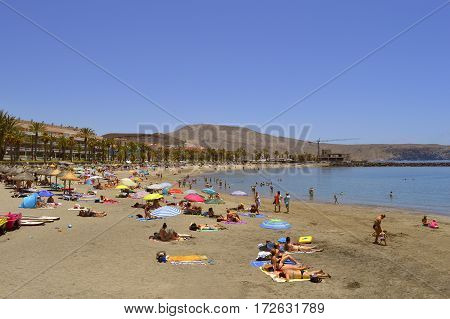 Playa De Las Americas beach Tenerife Canary Islands Spain Europe - June 12 2016: Tourists on the beach enjoying the sun