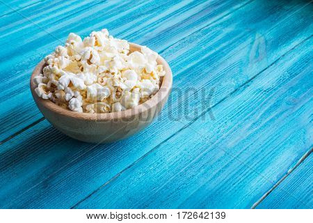 Popcorn In Wooden Plate On A Blue Background