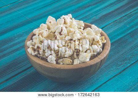 Popcorn In Wooden Plate On A Blue Background