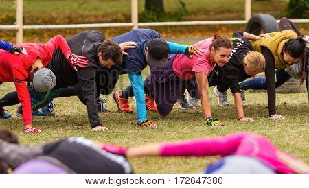 Kiev Ukraine - October 08. 2016. Street workout CrossFit training. Men and women perform a horizontal plank his hand resting on the shoulder of another athlete.