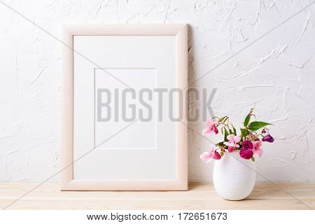 Wooden frame mockup with purple wildflowers in flowerpot. Empty frame mock up for presentation design.