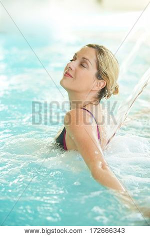 Woman in spa pool enjoying water jet