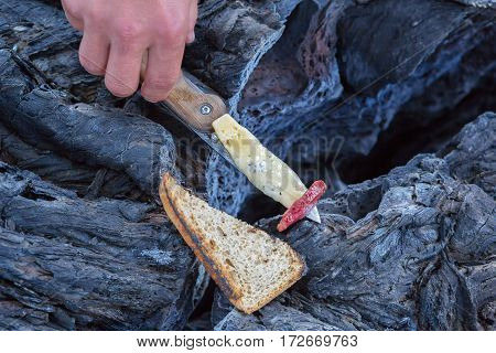 Barbecue over the fire in crack of frozen lava field at the Tolbachik volcano, after eruption in 2012, Klyuchevskaya Group of Volcanoes