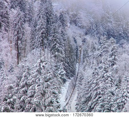 Funicular railway connecting the village of Stoos and the town of Schwyz in Switzerland on a foggy day in winter.