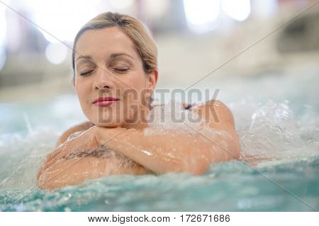 Middle-aged woman enjoying thermal bath in thalassotherapy center