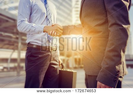 Success and Happiness concept Business man handshake at city outside office.