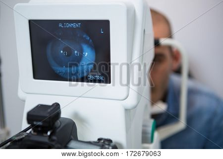 Man looking at eye test machine in ophthalmology clinic