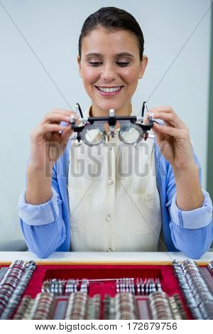 Optician looking at trial frame in optical store