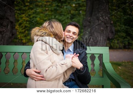 Young Boy And Girl Hugging And Kissing, Sitting On The Bench