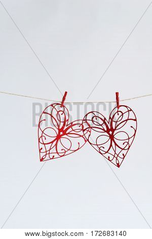 Red hearts with patterns cut out of paper on a light background.