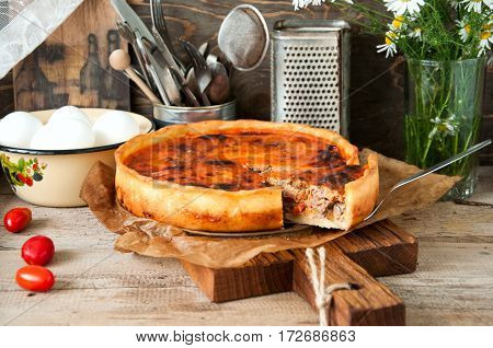 Vegetable and meat open pie on a board. Rustic style. Toned.