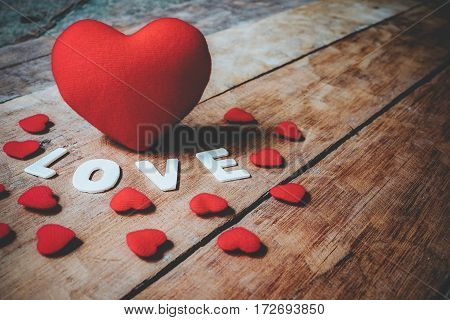 Caption word love and heart on wooden board close up.Valentines Day background concept Wedding day.Vintage tone