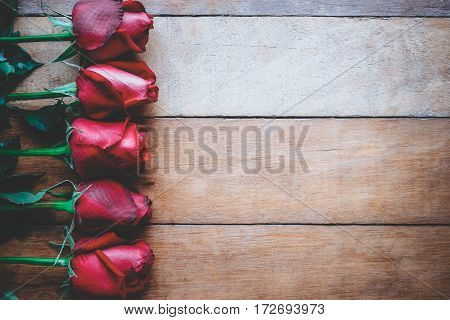 Red roses on wooden background with copy space.Valentines Day background concept Wedding day.Vintage tone