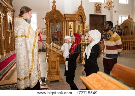 ALMATY KAZAKHSTAN - DECEMBER 17: Christening ceremony on December 17 2013 in Almaty Kazakhstan. Family celebrating baptism in Orthodox Church - Monastery of St. Matrona