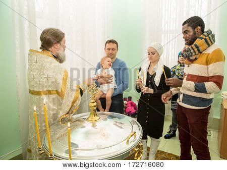 ALMATY KAZAKHSTAN - DECEMBER 17: Christening ceremony on December 17 2013 in Almaty Kazakhstan. Family celebrating baptism in Orthodox Church - Monastery of St. Matrona