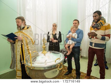 ALMATY KAZAKHSTAN - DECEMBER 17: Christening ceremony on December 17 2013 in Almaty Kazakhstan. Family celebrating baptism in Orthodox Church - Monastery of St. Matrona