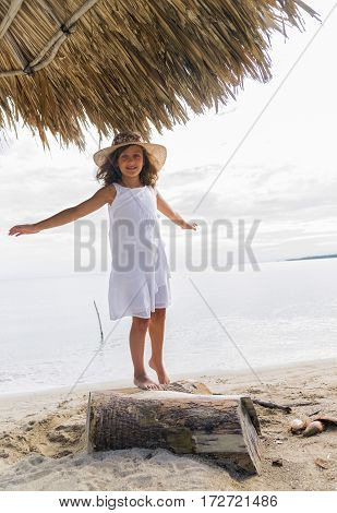 Little girl playing with trunk on the beach