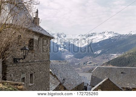 Landscape of a mountain village with snowy peaks in the background