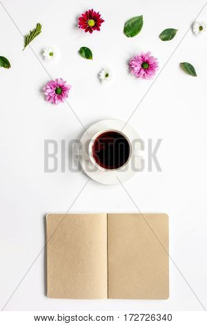 Froral flat lay with cup of coffee and craft notepaper on white background top view mockup
