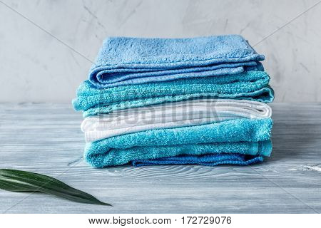 blue towels pile in housekeeping set on laudry gray background mockup
