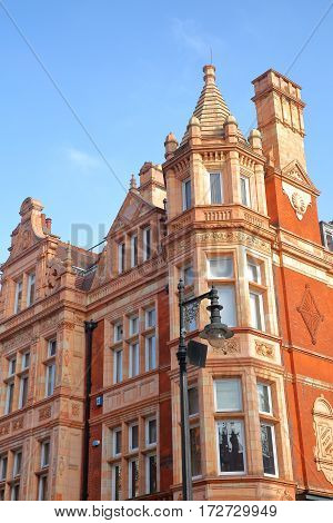 LONDON, UK - FEBRUARY 13, 2017: Red brick Victorian houses facades in S Audley Street (borough of Westminster)