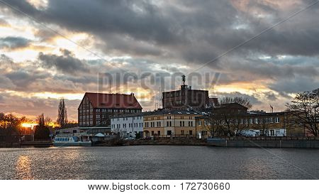 The old town on the river at sunset. Boat at the wharf.