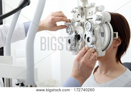 woman doing eyesight measurement with optical phoropter