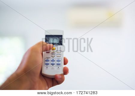 Remote control from the air conditioner in the hands of the men of remote control. The temperature and the climate in the building.