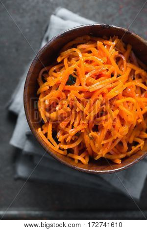 Carrots in Korean with spices on a metal table clozeup vertical