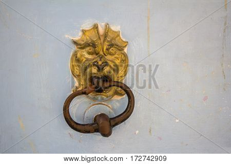 Old rusty metal door knocker on an old wooden entrance door
