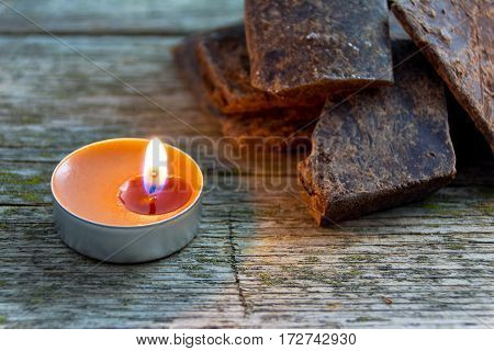 broken natural handmade chocolate in light of lit candle