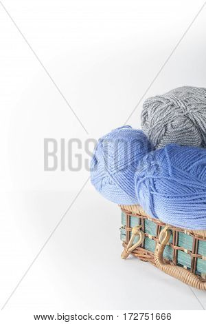 Colored yarn on a white background. Skeins of wool yarn for knitting. Balls of wool of different colours for handmade knitting on a wooden background with copy space for ad