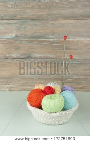Colored yarn on a white background. Skeins of wool yarn for knitting. Balls of wool of different colours for handmade knitting on a wooden background with copy space for ad