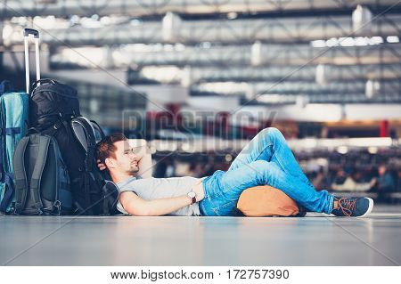 Traveler waiting at the airport departure area for his delay flight.