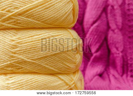 Yellow Balloon of Yarn on the Pink Knitted Item Background.Hand Made;Fancywork.Selective Focus