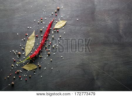 Red Pepper Pungent Spices And Bay Leaf On The Black Tree. View From Above.