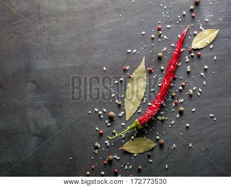 Red Pepper Pungent Spices And Bay Leaf On The Black Tree. View From Above.