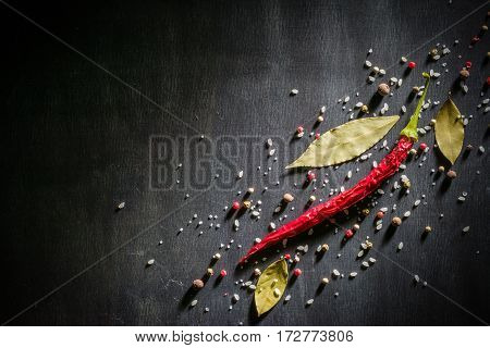 Red Pepper Pungent Spices And Bay Leaf On The Black Tree. View From Above.