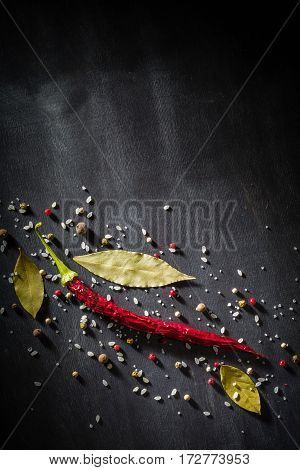 Red Pepper Pungent Spices And Bay Leaf On The Black Tree. View From Above.