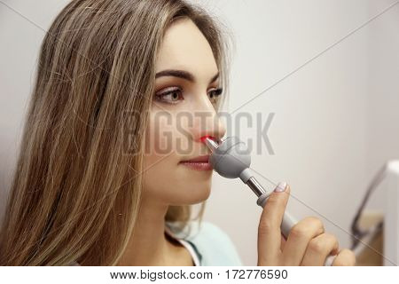 Young woman undergoing light treatment in modern clinic