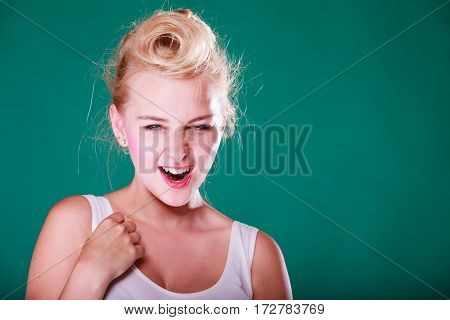 Face expression emotions concept. Young woman with pin up hair being astonishment shocked and disgust. Studio shot on green background