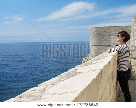 woman sightseeing at Dubrovnik ancient wall in Croatia