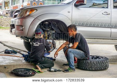 Kota Kinabalu,Sabah-Aug 11,2016:The car mechanics checking shock absorber in car suspension at garage at Kota Kinabalu,Sabah.Shock absorbers can also leak as they are filled with oil.