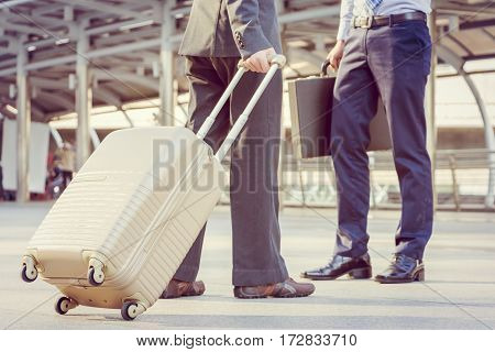 Businessman traveler with luggage at city background