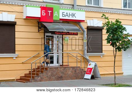 GOMEL BELARUS - SEPTEMBER 16 2016: Unknown woman enters into office of BTA Bank on Lenin street 26 Gomel Belarus