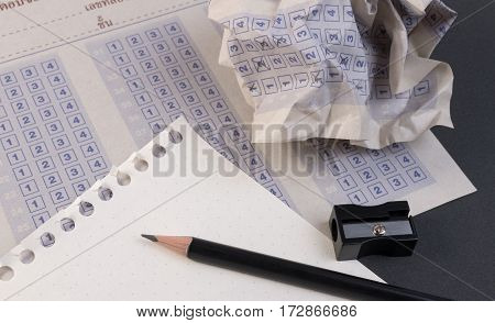 Crumpled paper ball of vintage classic answer sheet with pencil sharpener and paper reduction. Cross the right answer in the box with blank answer. Answer sheet concept.