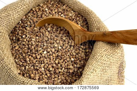 Buckwheat with wooden spoon in jute sack close up