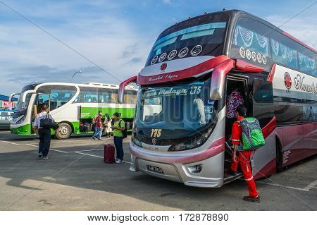Menumbok,Sabah-Aug 19,2016:People walking up to the bus in bus terminal at Menumbok,Sabah.People used to take bus from Kota Kinabalu to Menumbok then ferry to Labuan island to enjoy tax free shopping