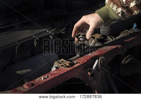 Checking the coolant level in the car. 
The cap of the radiator, check fluid, replacement fluid. 
Mechanic pouring coolant to the radiator. 
Male lists the coolant in the cooling system.