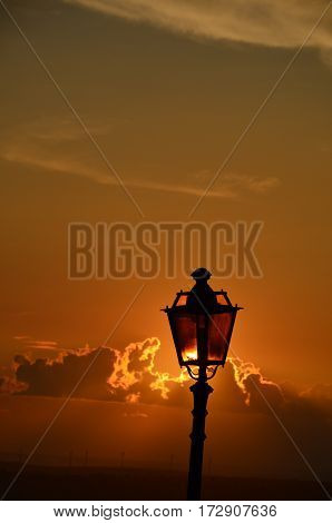 A Lit Vertical Lightposts with Sunrise Background